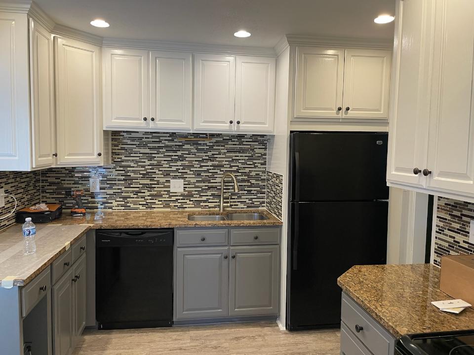 Compact kitchen with dark appliances and backsplash