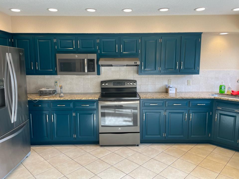 Bold kitchen with teal cabinets and stainless